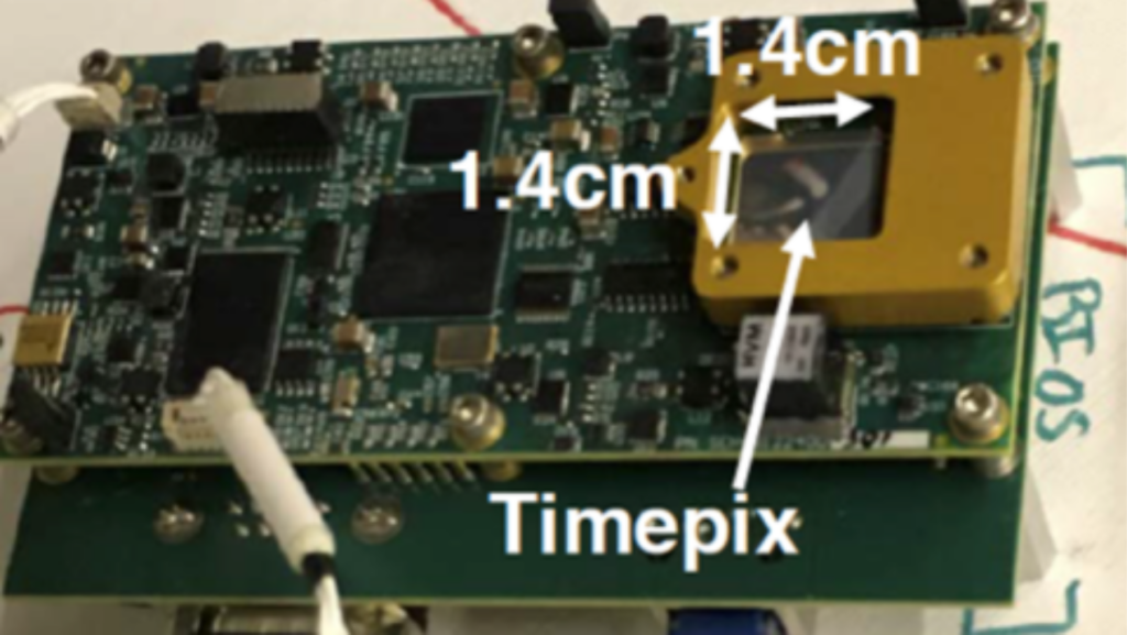 A small circuit board used within LETS instruments that spans approximately 12 cm, based on the arrows used here for scale. The Timepix technology is specifically indicated to the right. Image: NASA / JSC